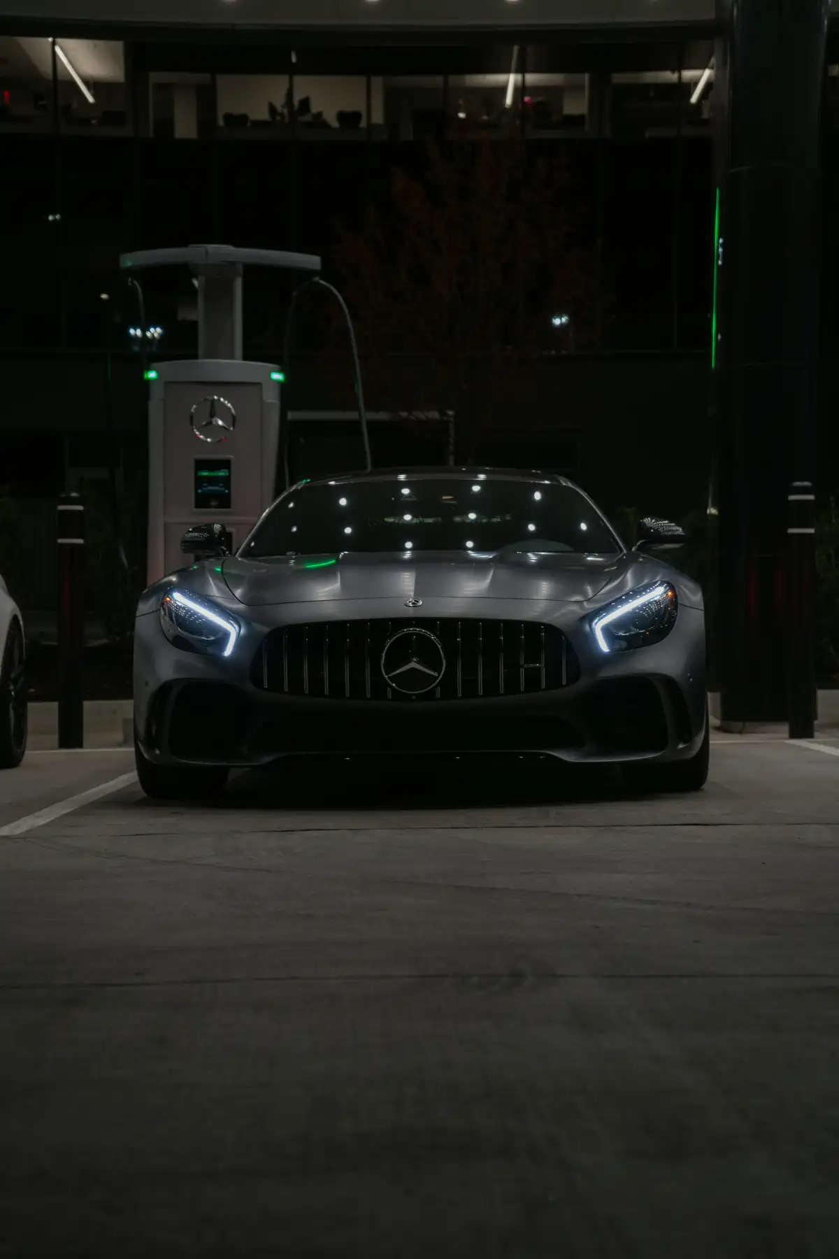 Two cars parked in a parking lot at night